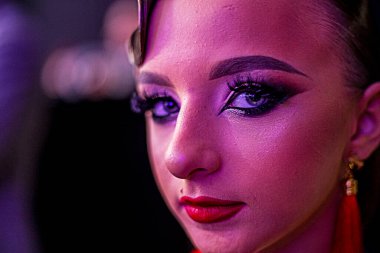 Parlak makyajla vurgulanmış güzel açık renk gözler koyu bir arka plana karşı. Moda ve tarz