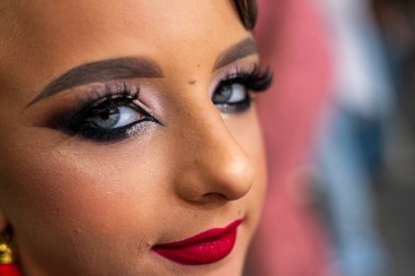 Parlak makyajla vurgulanmış güzel açık renk gözler koyu bir arka plana karşı. Moda ve tarz