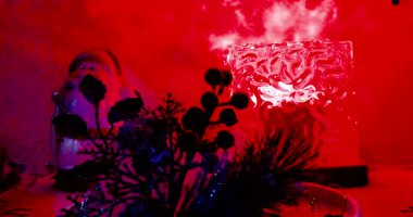 Şirin Noel Baba heykelciği. Çiçek silueti ve kırmızı ışıkla.