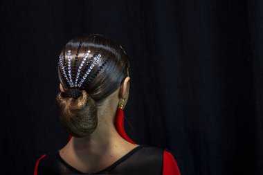 Siyah arka planda kırmızı küpe takan genç bir dansçının güzel profili. Balo dansı görüntüsü