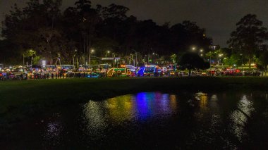  Ibirapuera Parkı 'ndaki Noel Ağacı' nın havadan görünüşü, suda bir sunum ve birçok insan izliyor.