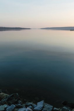 Batan güneşli güzel bir akşam manzarası. Engin sakin nehir.
