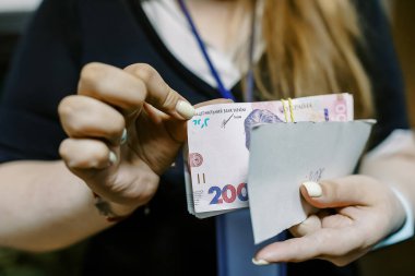 Ukrayna ulusal para birimi kadınların elinde, 200 Hryvnia yakın plan, Ukrayna parası.