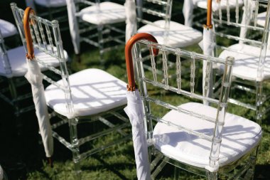 Düğün töreninde şık beyaz şemsiyeler, güzel berrak sandalyeler..