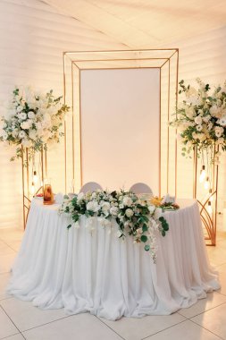 Düğün masası şık ve sofistike dekorlarla süslenmiş. Şölen masasında çiçekler.