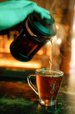 Garson çaydanlıktan temiz bir fincana sıcak çay doldurur.. 