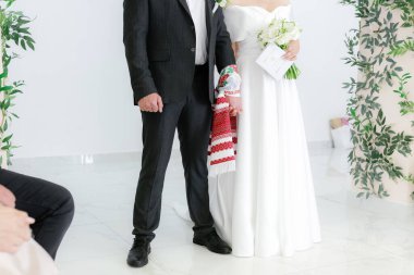 Yeni evlilerin elleri, nazik dokunuşlar, altın yüzükler. Geleneksel Rushnik