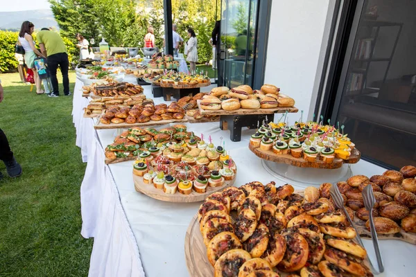 Outdoor catering buffet with a variety of food snacks and appetizers.