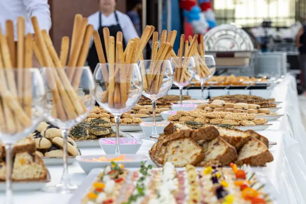 Yemek masasında atıştırmalık ve içeceklerle yemek servisi.