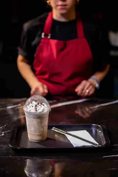Kafede cappuccino yapan bir kadın.