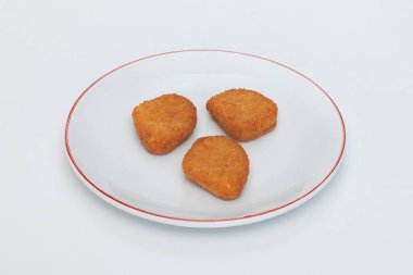 Kızarmış tavuk külçeleri beyaz arka planda beyaz tabakta. yüksek kaliteli fotoğraf