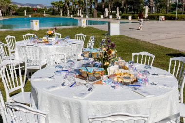 Mumlar, çiçekler ve mumlarla dolu bir düğün masası.