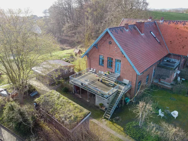 Beautiful house or cottage in the hills spring time. High quality photo.brick house in Germany in the forest. a lot of junk around the house