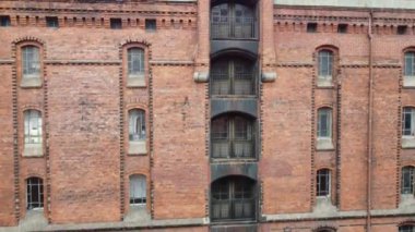 Speicherstadt 'ta Hamburg, Almanya' da köprüleri olan eski kırmızı tuğlalı binalar. Yüksek kalite FullHD görüntüsü. Eski şehrin kanallarında ve rıhtımlarında uçuyor.