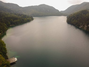 Alp gölünün muhteşem manzarası kristal berrak yeşil su ve mükemmel mavi gökyüzü. Zell am See 'deki Zeller Gölü ile Alpler' deki güzel dağ manzarasının panoramik görüntüsü. Yüksek kalite fotoğraf