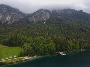 Gün batımında manzaralı göl manzaralı Alman ahşap yazlığı. Yüksek kalite fotoğraf. Dağlarda bir gölün kıyısında bir ev. Bavyera Alp Dağları 'nda hayat. Kimse yok.