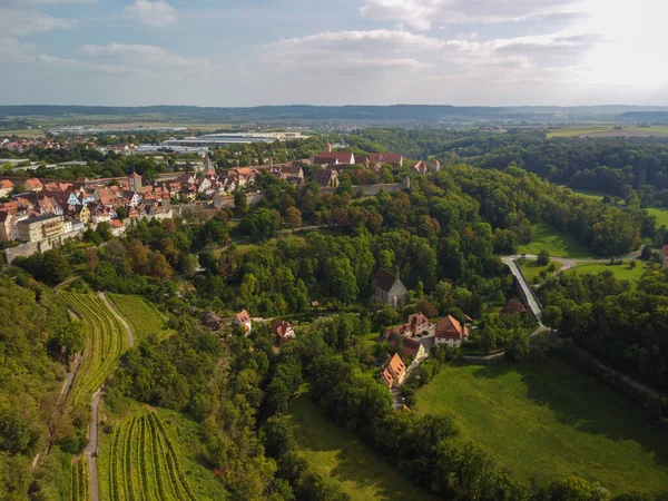 Ortaçağ kasabası Rothenburg ob der Tauber 'in klasik manzarası ortaçağ duvarı ve ormanı ile güzel güneşli bir günde mavi gökyüzü ve bulutlar baharda, Bavyera, Almanya. Yüksek kalite fotoğraf