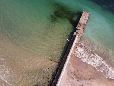 Eski beton iskele ya da deniz fenerli dalgalı zümrüt deniz suyu ve insansız hava aracı görüntüsü. Yüksek kalite fotoğraf