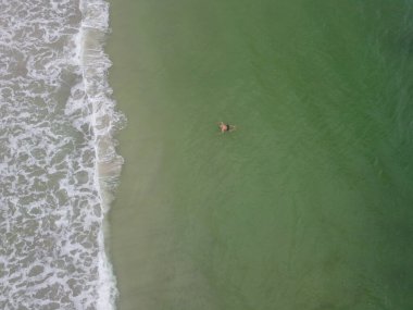 Yüzen ve rahatlayan bir adamın yan görüntüsü. Stand Up Paddle SUP 'de denizdeki sportif adam. Aktif ve sağlıklı yaşam kavramı doğayla uyum içinde. Yüksek kalite fotoğraf