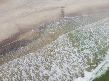 Kara bulutlu bir günde Ukrayna 'nın Odessa şehrinde cankurtaran duruyor. Yüksek kalite fotoğraf. Kumsaldaki cankurtaran kulesi, gri gün, kumları kaplayan dalgalar.