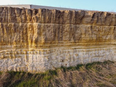 Küçük taşlar ve tozla kaplı sarı ve kahverengi toprak desenli bir arka plan. Kazı kir dokusu açığa çıktı. Yüksek kalite fotoğraf. Bir kaya heyelan, tüm toprak ve taş katmanları görülebilir. kazılar.