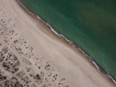 Metnin için fotokopi alanı olan turkuaz suyla çarpıcı güzellikteki deniz manzaralı bir kumsalın insansız hava görüntüsü. Turkuaz suyu ve hava aracı görüntüsü olan güzel kum plajı.. 
