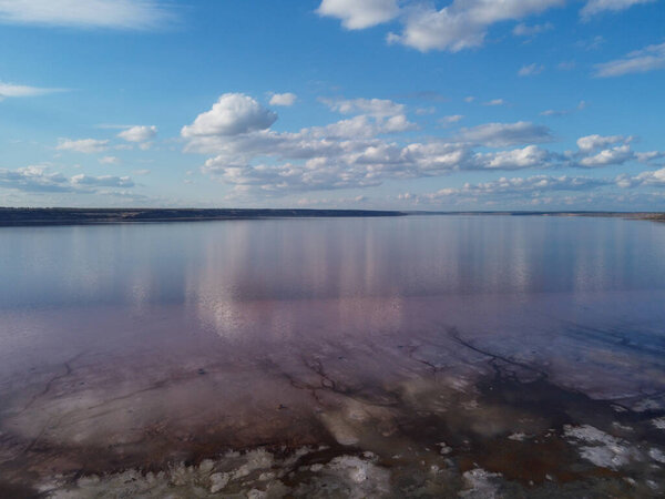 photo of the horizon,where fluffy white clouds are reflected in the calm,deep blue sea.The reflection creates a mirror image of the clouds, doubling their beauty and adding a serene, dreamlike quality