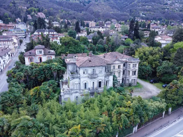 An old, abandoned villa in Italy, with cracked walls, overgrown plants, and a rusty gate. The villa was built in the 1850s. It is now a popular destination for urban explorers and photographers.