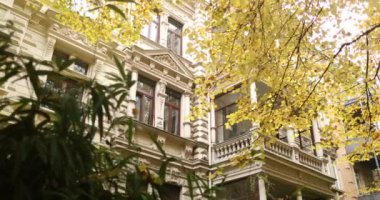 Rich old building in residential area surrounded by elegant autumn trees. High quality 4k footage