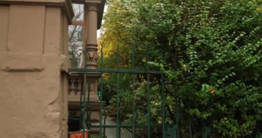 Approaching german stone mansion guarded by fence with luscious greenery. High quality 4k footage
