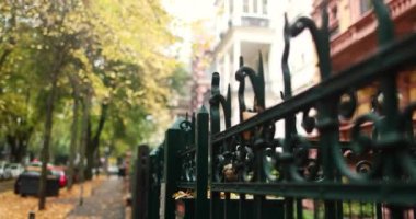 Fancy dark green steel fence in residential city street with autumn trees . High quality 4k footage
