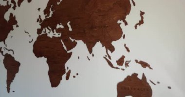 Full view of wooden world map inside modern room with white background. High quality 4k footage
