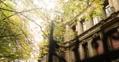 Old fence guarding a Elegant mansion with beautiful golden autumn trees. High quality 4k footage