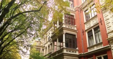 Old style red building in residential area with trees durring fall season. High quality 4k footage