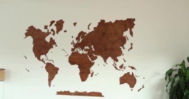 Wooden world map full view elegant interior design on white wall room. High quality 4k footage