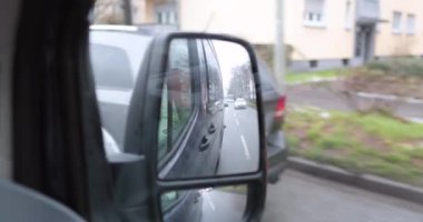 Driving a van on a busy street during winter in germany, side mirror view . High quality 4k footage