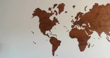 Wooden world map in elegant designed modern room with white wall. High quality 4k footage
