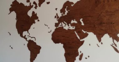Wooden world map zoom on europe in simple elegant modern room white wall . High quality 4k footage