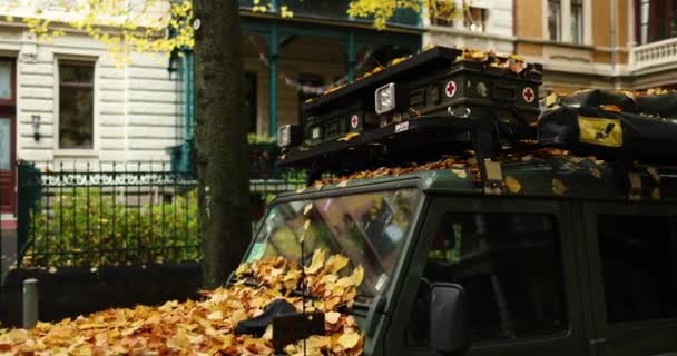Темно Зеленый Джип Припаркованный Перед Жилыми Домами Оранжевые Осенние Листья — стоковое видео