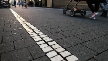 People and stroller passing by busy shopping street on nice summer day. High quality FullHD footage