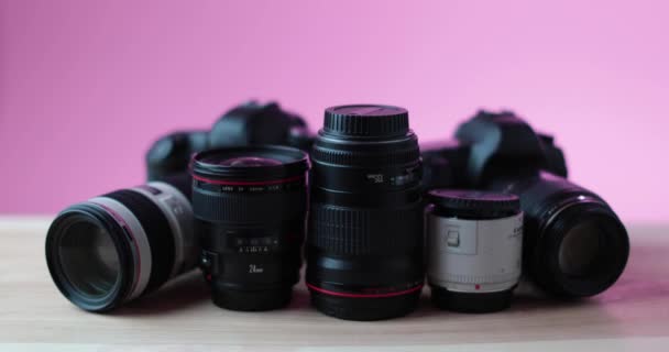 Камеры Объективы Фотоаппаратов Лежат Современном Столе Простом Розовом Фоне Высококачественные Видеоклип