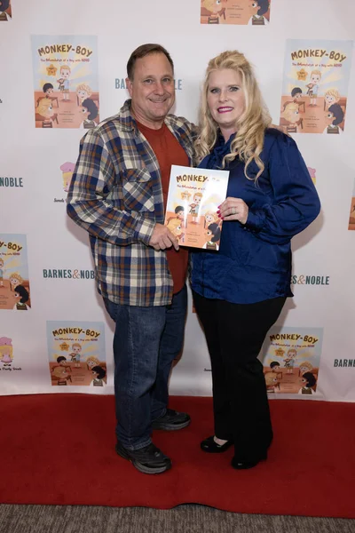 夫と作家のレイチェル スウィッツァーは 著者レイチェル スウィーツァーの モンキー Adhdの男の子の冒険 ブックにサインし バーンズとノーブルでグローブ ロサンゼルス カリフォルニア — ストック写真