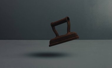 Eski paslı demir veya düz demir gri arkaplanda yüzer .