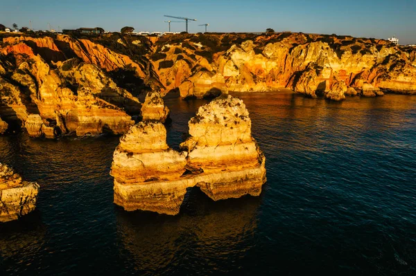 ポルトガルのラゴス近くのポンタ ピエデ Ponta Piedade で日の出に海岸の黄金の崖 海のアーチを持つ壮大な岩の形成 大西洋による夏の休暇 アルガルヴェの有名なビーチ — ストック写真