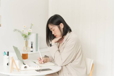 Asyalı iş adamı ve yazar kadın kitap üzerine yeni bir fikir yazıyor.