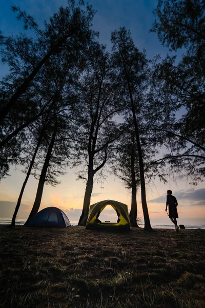 日の出と海の背景を持つビーチでシルエットのキャンプテント — ストック写真