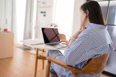 Asyalı kadın serbest yazar, evde çalışırken rahat ve mutlu.