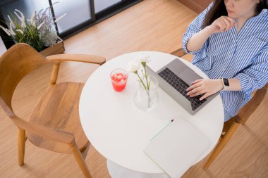 İnternet afişi Asyalı kadın serbest yazar evde çalışırken rahat ve mutlu.