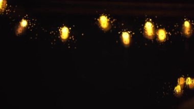  Geceleri pencereye düşen yağmur damlaları sırasında aydınlatma