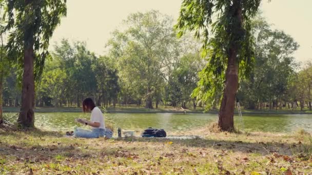 Asyalı Bir Kadınla Insanların Aktivite Kavramı Rahatlar Kitap Okurken Gölün — Stok video
